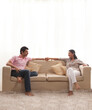 © IndiaPix - Loving young couple holding hands while sitting on sofa
