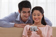 © IndiaPix - Smiling young couple looking at digital camera together