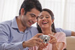 © IndiaPix - Happy young couple enjoying while looking at digital camera