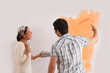 © IndiaPix - Happy beautiful woman looking at man while painting wall