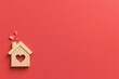 © Ryzhkov - Wooden house cut-out with a heart opening and small paper hearts, featuring a warm sanded texture on a crimson background with copy space for home and family campaigns