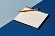 © Ryzhkov - Spiral-bound desk calendar with a blank grid and yellow pencil, featuring a textured paper finish on a two-tone blue background for planning and scheduling mockups