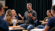 © Maksym Tereshchenko - A diverse multicultural keynote presenting workshop fills a minimalist stage studio, a Kenyan man, an Irish woman, and a Mongolian youth each rehearse identity and reinvention pitches, the adult ide