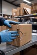 © Ankit - Warehouse worker inspecting damaged cardboard shipping box in industrial storage facility area