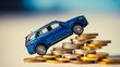 © Baqir khan - Blue car balanced on stacks of coins representing vehicle finance and investment