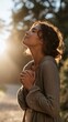 © The Little Hut - Young woman with eyes closed in prayer or meditation outdoors bathed in warm golden sunlight, embodying peace and serenity