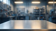 © graphicview35 - Closeup of a brushed metal workbench surface in a blurred industrial workshop background