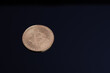 © Claudia Nass - A bitcoin coin is lying on a dark surface with shadows.