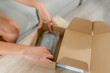 © ADDICTIVE STOCK - Woman pack second-hand item for online marketplace sale