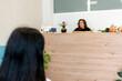 © ADDICTIVE STOCK - Osteopathy clinic receptionist welcoming patient at reception