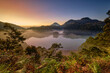 © Travel 'n' Lifestyle - View of Telaga Warna in Dieng Park at sunrise with mist over the water and surrounding mountains in Kejajar, Central Java, Indonesia.