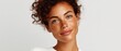 © Phanupong - Portrait of young woman with curly brown hair and freckles against plain light background representing natural beauty and authentic confidence
