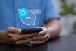© Kanchon Creative - Person using smartphone with AI chatbot conversation interface.
