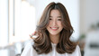 © visoot - Smiling woman with long wavy brown hair in bright modern interior, natural makeup, cheerful expression, casual style