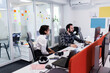 © Nikola Spasenoski - Business professionals discuss project details in a modern office with colorful sticky notes during work hours