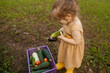© ADDICTIVE STOCK - Toddler harvest organic vegetable in home garden