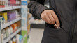 © Ronald Red - Woman shoplifter hiding stolen product in pocket inside store. Kleptomania and crime concept. Person committing theft in supermarket. Surveillance monitoring and security risk problem.