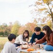 © Yka - 秋の公園で軽食を分け合う友人たち