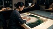 © thom - Asian female architect working on building plans in office at night