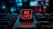 © MheeP - A glowing red go live button on a keyboard highlights online content creation and digital broadcasting.