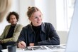 © Jibber  - Kreative Bewerberin bespricht ihr Portfolio in einem modernen Büro