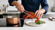 © areeba - Professional chef plating cooked lobster on a white plate in a modern restaurant kitchen