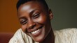 © GATE 22 - Close-up portrait of a young african-american woman with short hair. she is smiling widely, showing her teeth, and her eyes are closed. she appears to be happy and relaxed.