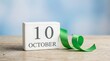 © MDMAHDI - October tenth date displayed as a reminder with a vibrant green ribbon on a natural wooden surface celebrating a significant occasion or special event