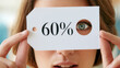 © Cozy Art - Young woman holding a discount tag showing 60% off in a store