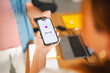 © Studio Marmellata - A customer uses their smartphone to make a secure contactless payment for a purchase at a checkout counter. The digital wallet screen displays the transaction amount.