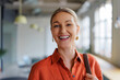 © BONNINSTUDIO/Stocksy - Woman smiling in modern office