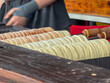 © Bjorn B - Traditional trdelnik chimney cakes baking on wooden spits at a street food market stall in Deinze, België