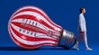 © BlackBridge Media - Businessman Pulling Giant Striped Light Bulb on Blue Background