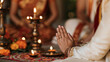 © Kateryna Arkhypova - Traditional Indian wedding prayer ceremony with bride and groom seated near flowers, lamps and ceremonial decorations, spiritual atmosphere, marriage ritual, Indian wedding,