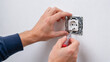 © Haldun - Electrician installing electrical wall socket outlet with screwdriver during home repair close up