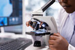 © DC Studio - Scientist places a tray sample under a microscope in a chemistry lab while research integrates biotechnology, molecular science and advanced diagnostics for medical discovery and laboratory research.