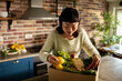 © Davor - Woman unpacking organic produce box in home kitchen