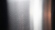 © EdiArtX - A close-up shot of a brushed stainless steel surface, showing the reflective quality and subtle texture of the metal. The light glints off the surface, creating bright highlights and dark shadows.