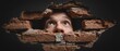 © santima - A person looking through a brick wall opening.