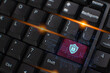 © OMEGA - A glowing green padlock icon illuminated on a computer keyboard key, symbolizing data security and digital privacy.