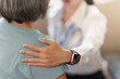 © Natee Meepian - Doctor comforting senior female patient during healthcare consultation at home