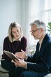 © 형근 최 - Generative AI, Senior advisor explaining a document on a clipboard to a young woman client indoors