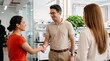 © PureVisualsFrame - Colleagues shaking hands and smiling during teamwork meeting in modern open office