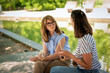© sepy - Two mid adult women friends having coffee outdoors