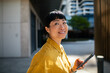 © Davor - Smiling professional woman using smartphone on a city street