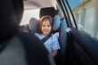© Johnér - Portrait of smiling girl sitting comfortably in safety seat inside car