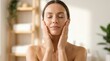 © Panuwat - A woman performing a face yoga massage for a skincare routine to improve skin tone and muscle.