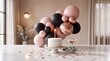 © Nadir Ali - Celebration of life and new beginnings. Baby figurine made of balloons holding lit candle on cake. Champagne glass and confetti on table for milestone event