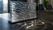 © USWATUN - A rectangular clear acrylic panel with a wavy texture stands on a black base, casting intricate caustic light patterns on a dark marble desk. Ideal for modern interior design.