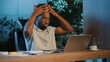 © Yuliia - Burnout exhausted African American business man thinking about difficult laptop trouble at late night office tired businessman male guy worker suffering with deadline work problem at evening company